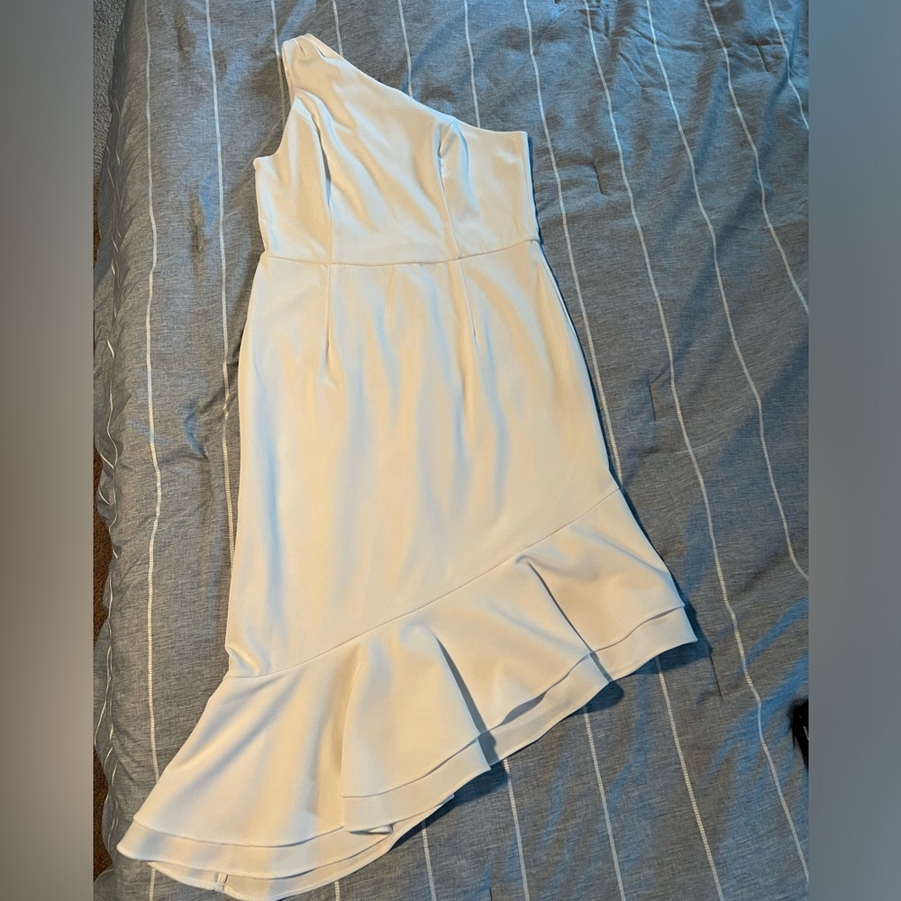 White one shoulder dress with a symmetrical, hemline and ruffle
